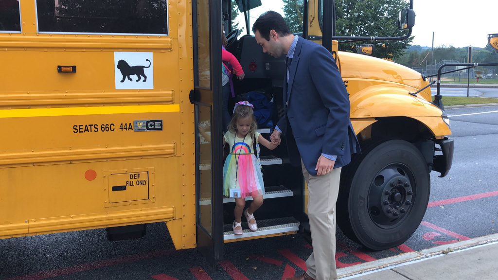 student arriving on school bus
